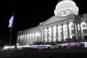 Night time view of the state capitol with trooper cars out front.