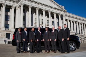 Members of UHP's executive protection team pose in front of a vehicle in front of the state capitol building.