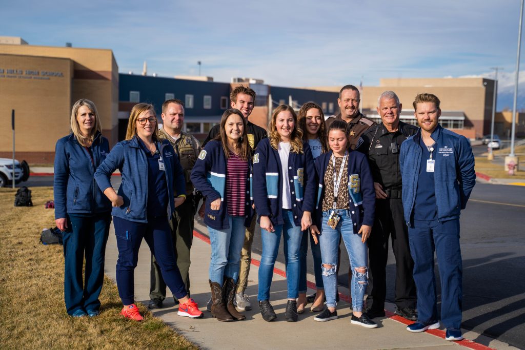 Intermountain Healthcare nurses, UHP, students and Salem PD members stand on the east side of Salem Hills High School for a group photo.