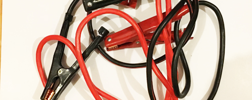 Red and black jumper cables are intertwined
