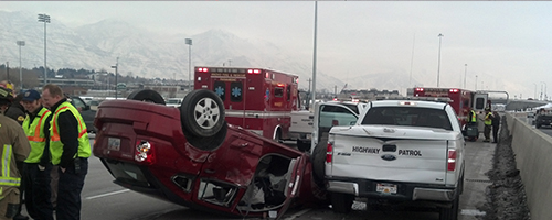 A vehicle is flipped over in the right emergency lane after hitting a UHP vehicle.
