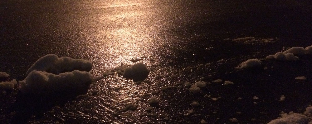 Close up of icy asphalt in the dark.