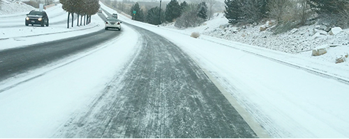 Snow covered road has more snow in between lanes than in the lanes.