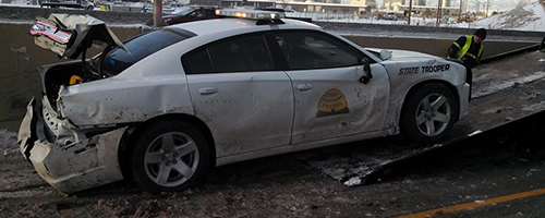 A UHP charger that has been hit in the rear is being loaded onto a tow truck